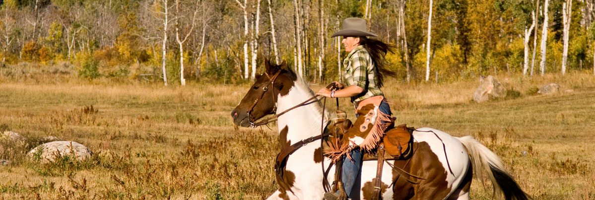 woman in Rand's hat riding a horse